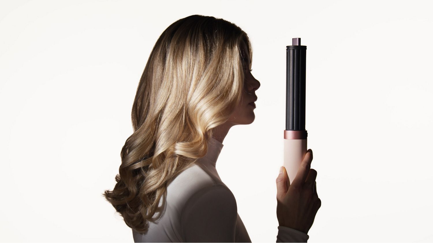 Model next to the Dyson Airwrap Co-anda2x multi-styler and dryer.