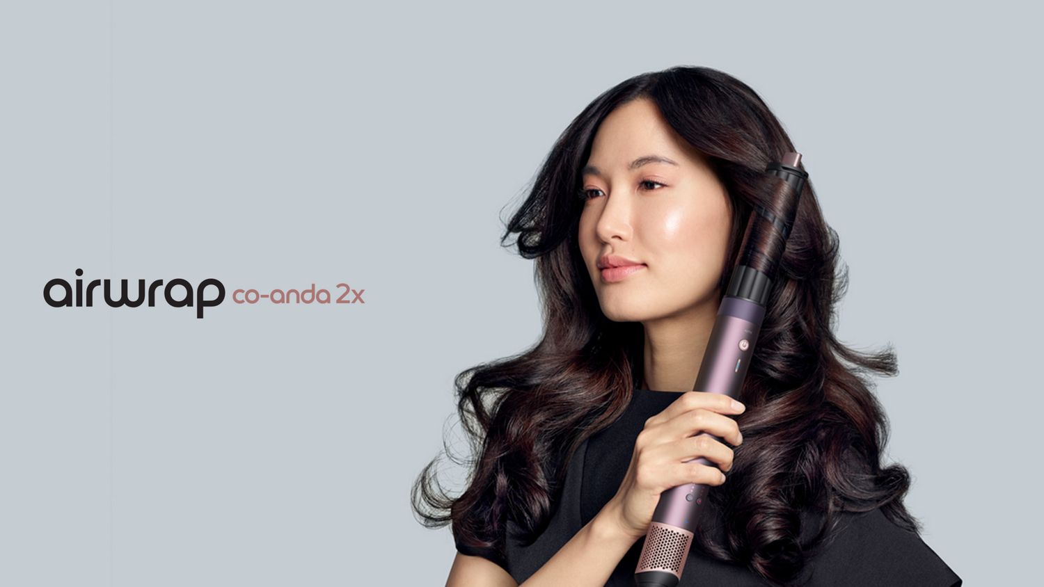 A model with dark hair adds curls using the Dyson Airwrap Co-anda2x multi-styler and dryer. The next-level multi-styler.