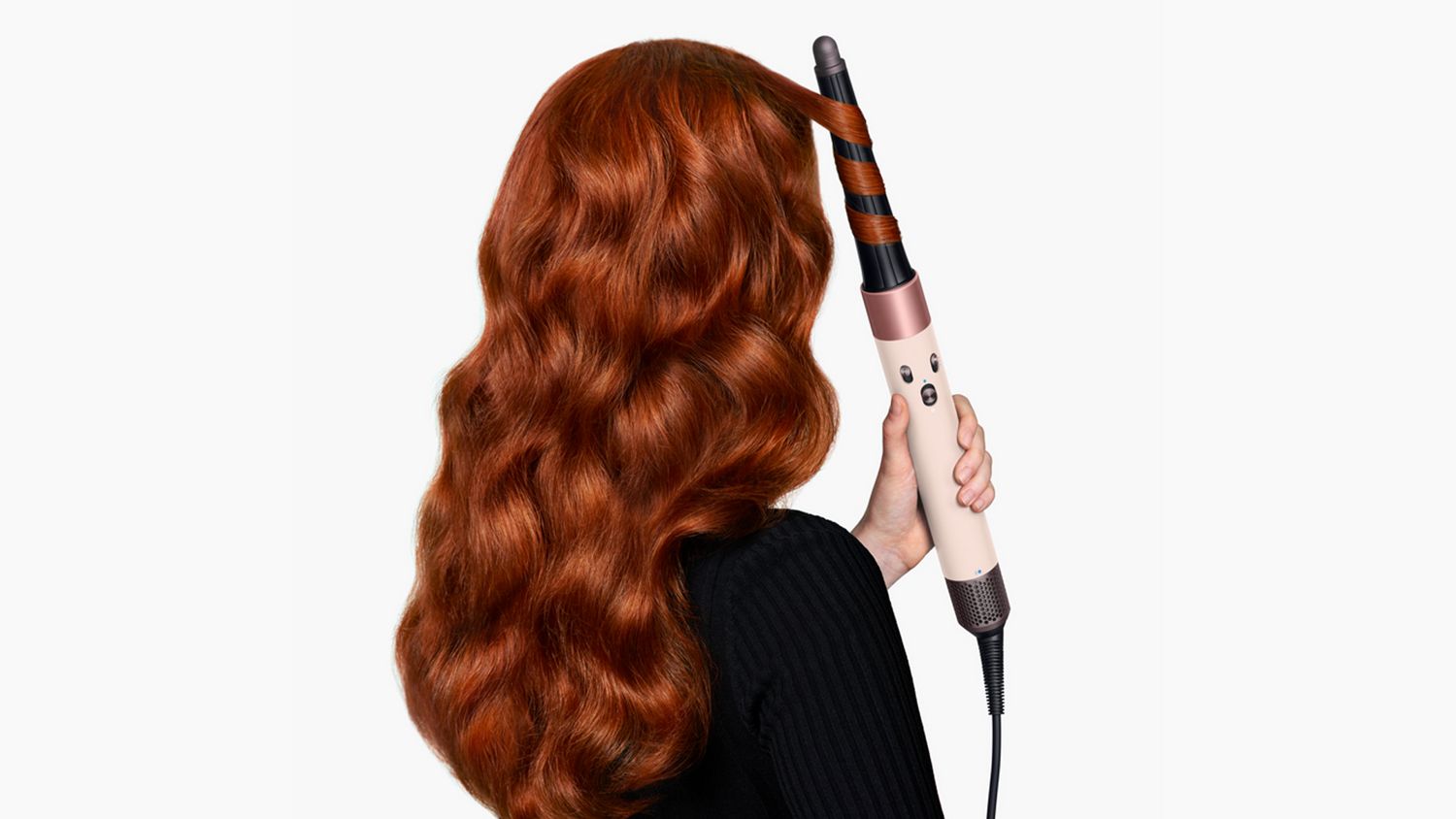 View of back of woman’s hair as she curls it with the Dyson Airwrap ID.