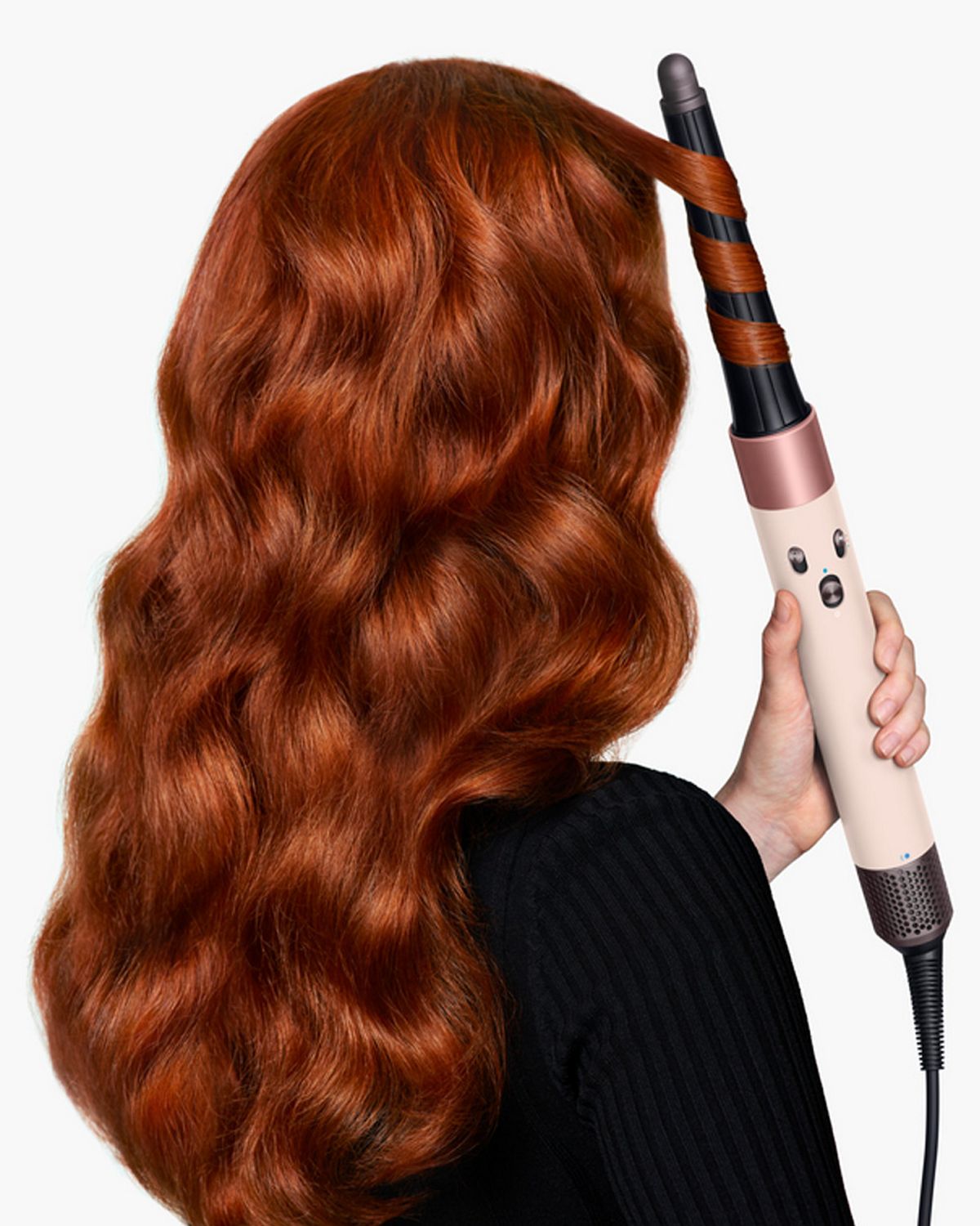 View of back of woman’s hair as she curls it with the Dyson Airwrap ID.