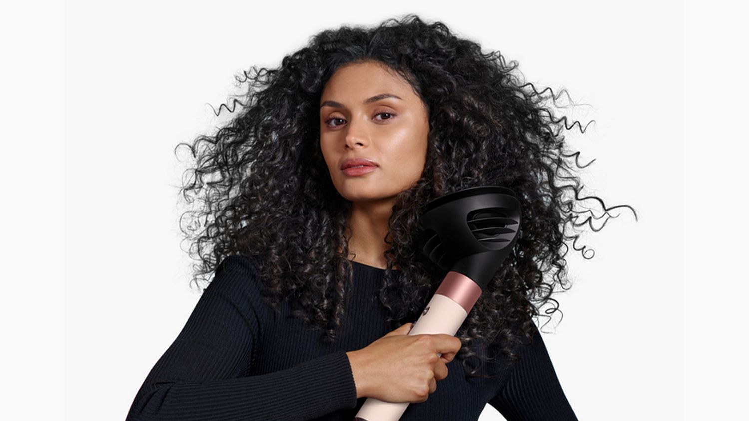 View of back of woman’s hair as she curls it with the Dyson Airwrap ID.