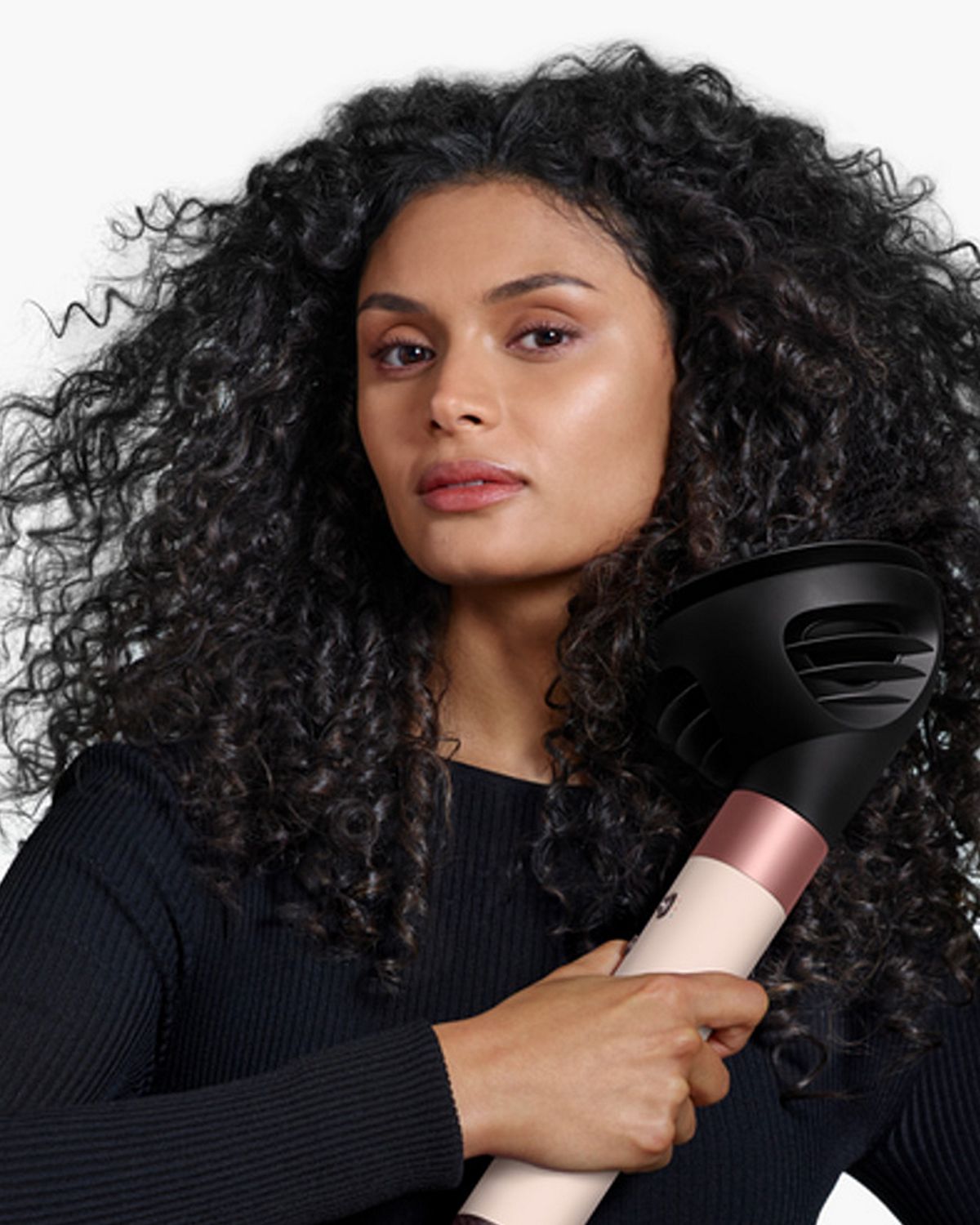 View of back of woman’s hair as she curls it with the Dyson Airwrap ID.