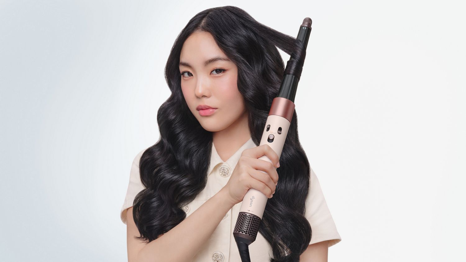 Ein Model lockt ihr Haar mit dem Dyson Airwrap i.d. Multi-Haarstyler und -trockner.
