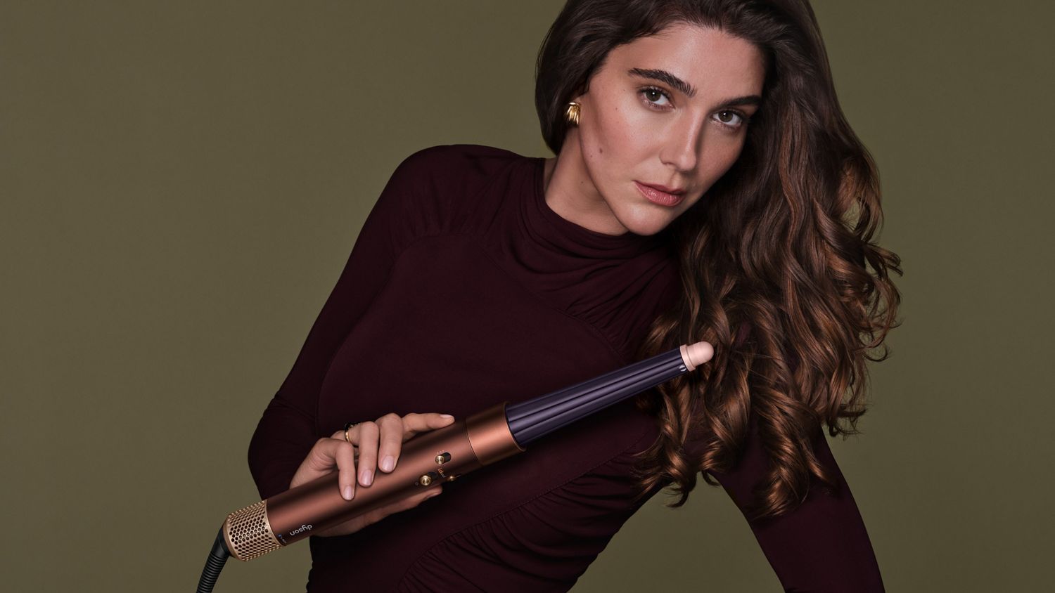 Model styles her hair with the Conical Airwrap barrel.