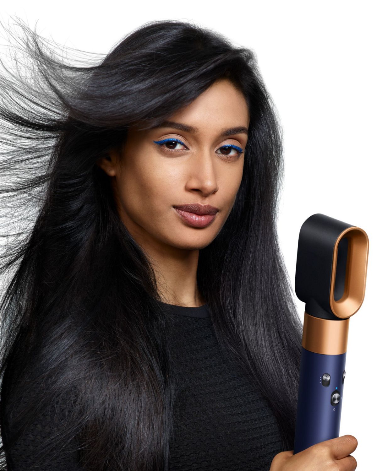 A redhead model curls her hair using the Dyson Airwrap i.d. multi-styler and dryer.