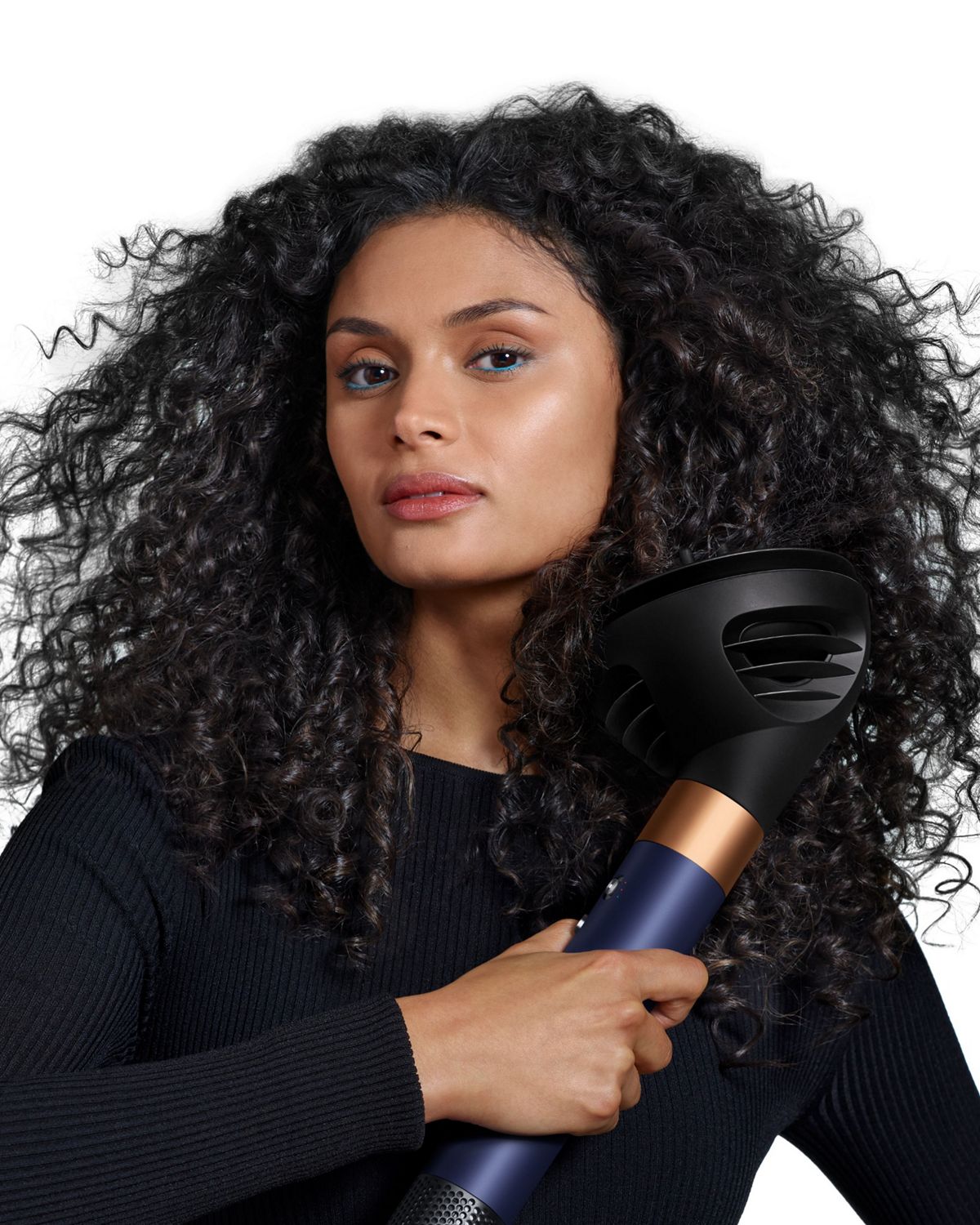 Front-on view of a woman adding volume to her hair with the Dyson Airwrap ID and the Wave+Curl diffuser.