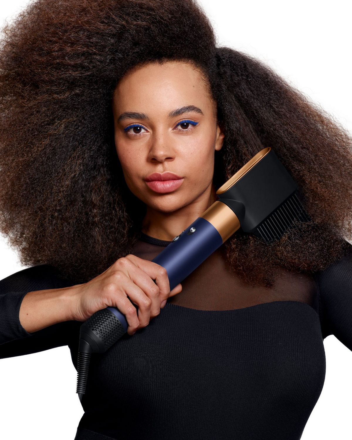 Model holding the Dyson Airwrap ID multi-styler and dryer with the Anti-tangle loop brush.