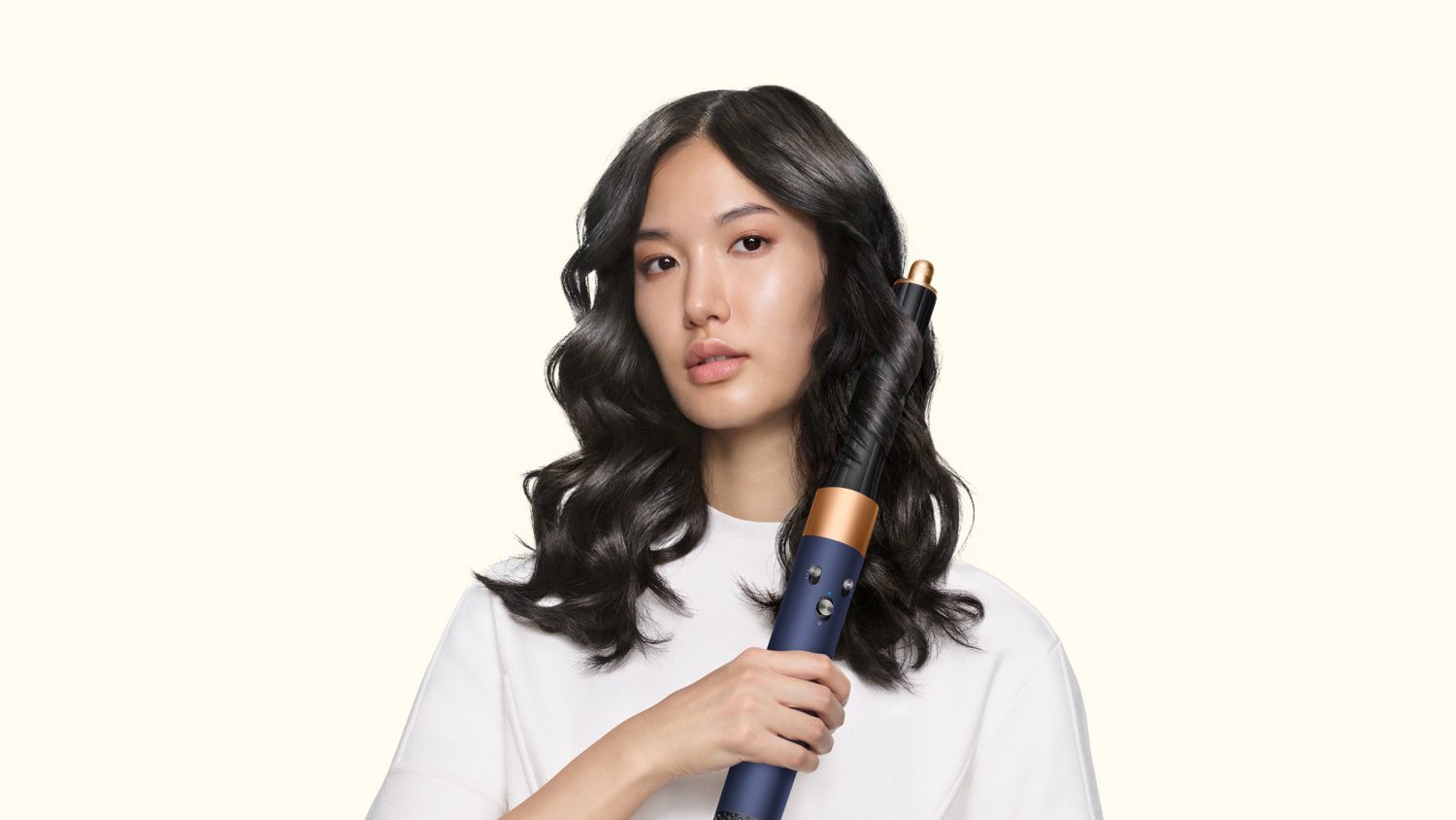 Model curls her hair using the Dyson Airwrap Origin multi-styler and dryer.
