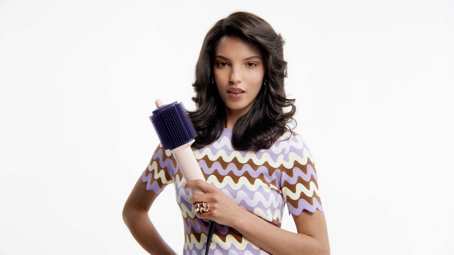   Model holds the Dyson Airsmooth styling brush.