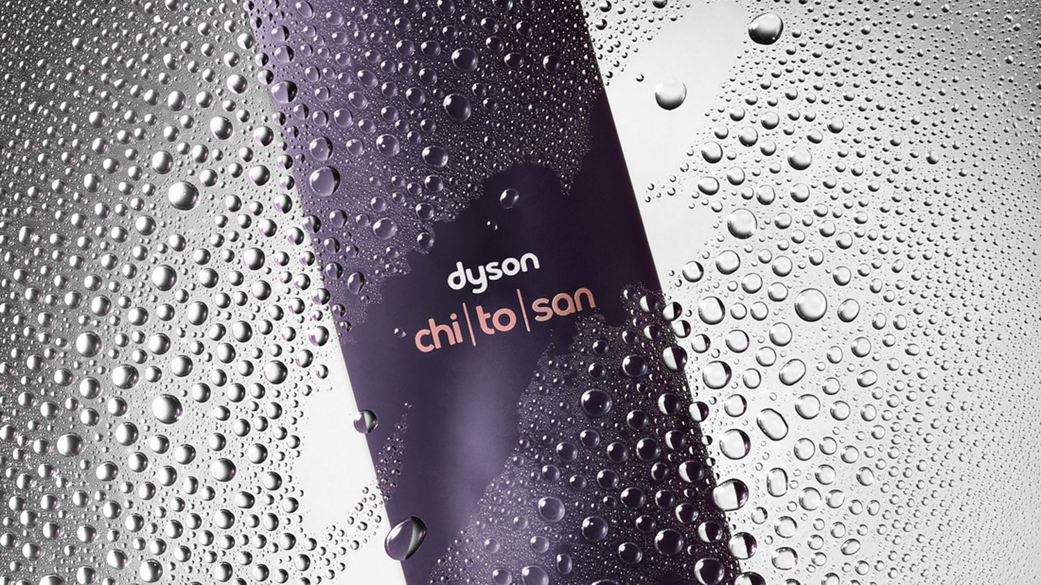 Dyson Chitosan Multi-use styling spray behind water droplets on a glass pane.