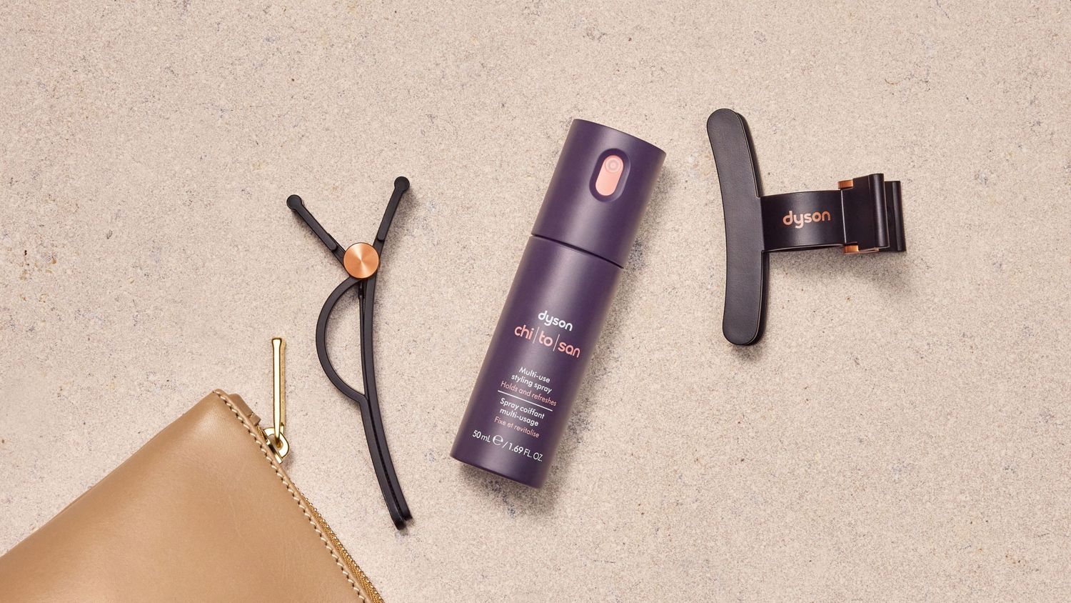 The Dyson Chitosan Multi-use styling spray travel mini with a set of Dyson hair clips.