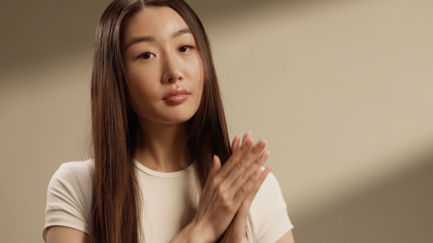 A model smooths Dyson Chitosan Post-style serum into her hair.