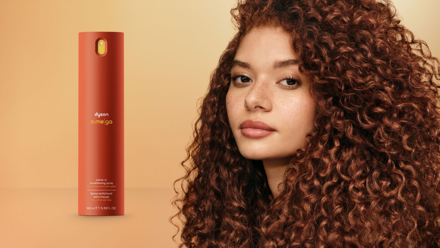 The Dyson Omega leave-in conditioning spray next to a model with styled curly hair.