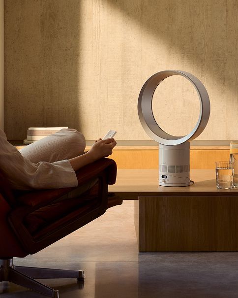 The Dyson Cool CF1 delivering a cool breeze to a person relaxing in a chair.