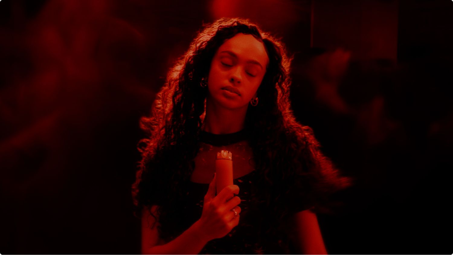 Dyson HushJet Mini Cool portable fan held in a hand in a club.