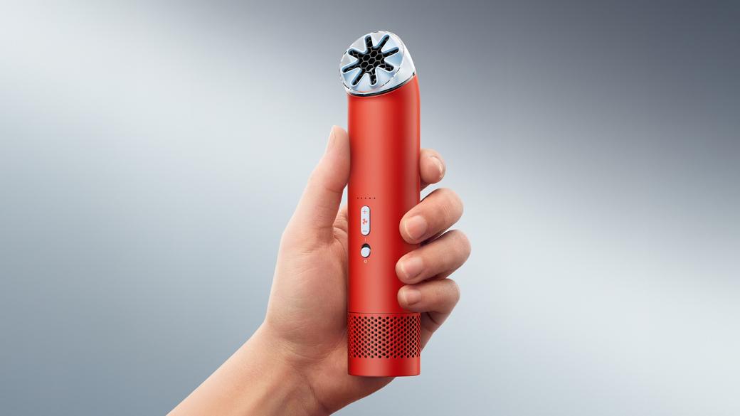 Prijenosni ventilator Dyson HushJet Mini Cool drži se uspravno u ruci.