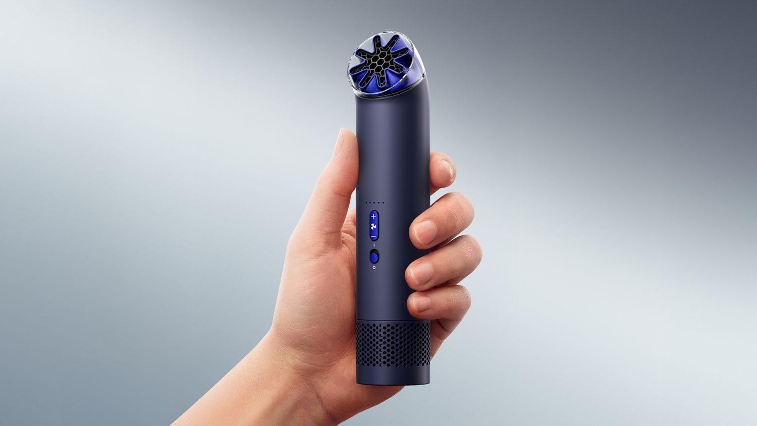 The Dyson HushJet Mini Cool portable fan held upright in a hand.