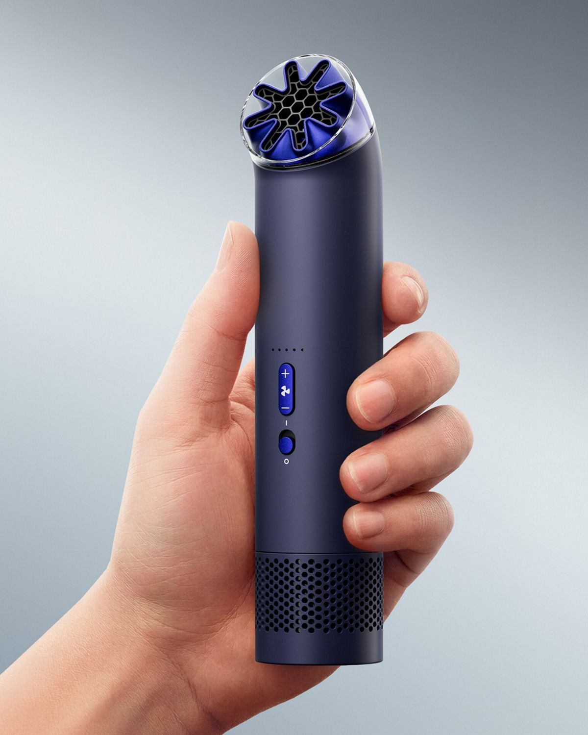 The Dyson HushJet Mini Cool portable fan held upright in a hand.
