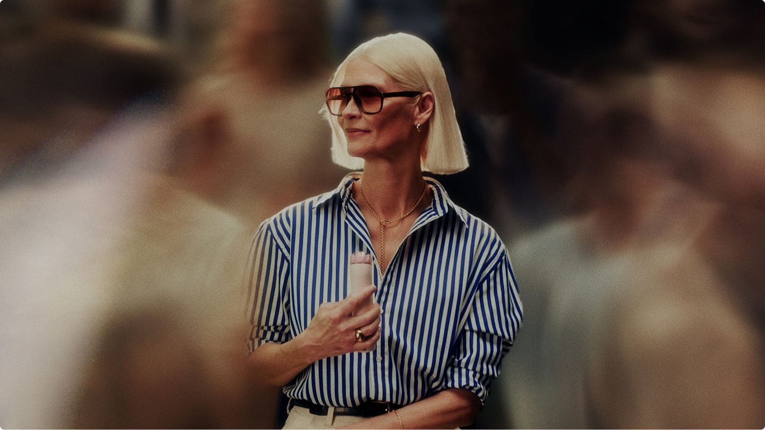 Dyson HushJet Mini Cool fan used by a tourist to cool down on a busy street.