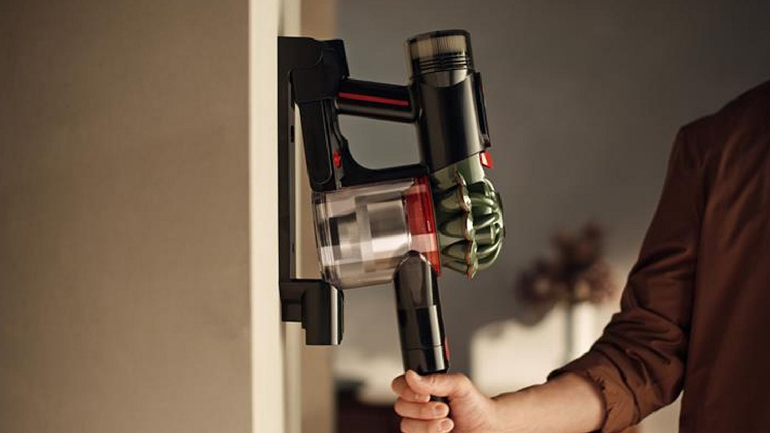 The Dyson V8 Cyclone vacuum is returned to its charging dock.