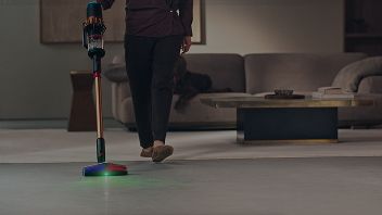 Une personne nettoie sa maison à l'aide de l'aspirateur sous-marin Dyson V16 Piston Animal et de la tête de nettoyage All Floor Cones Sense.