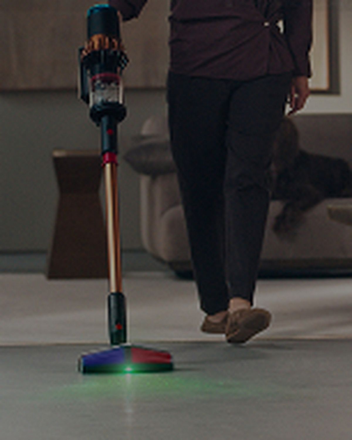 A person cleans their home using the Dyson V16 Piston Animal vacuum and the All Floor Cones Sense cleaner head.