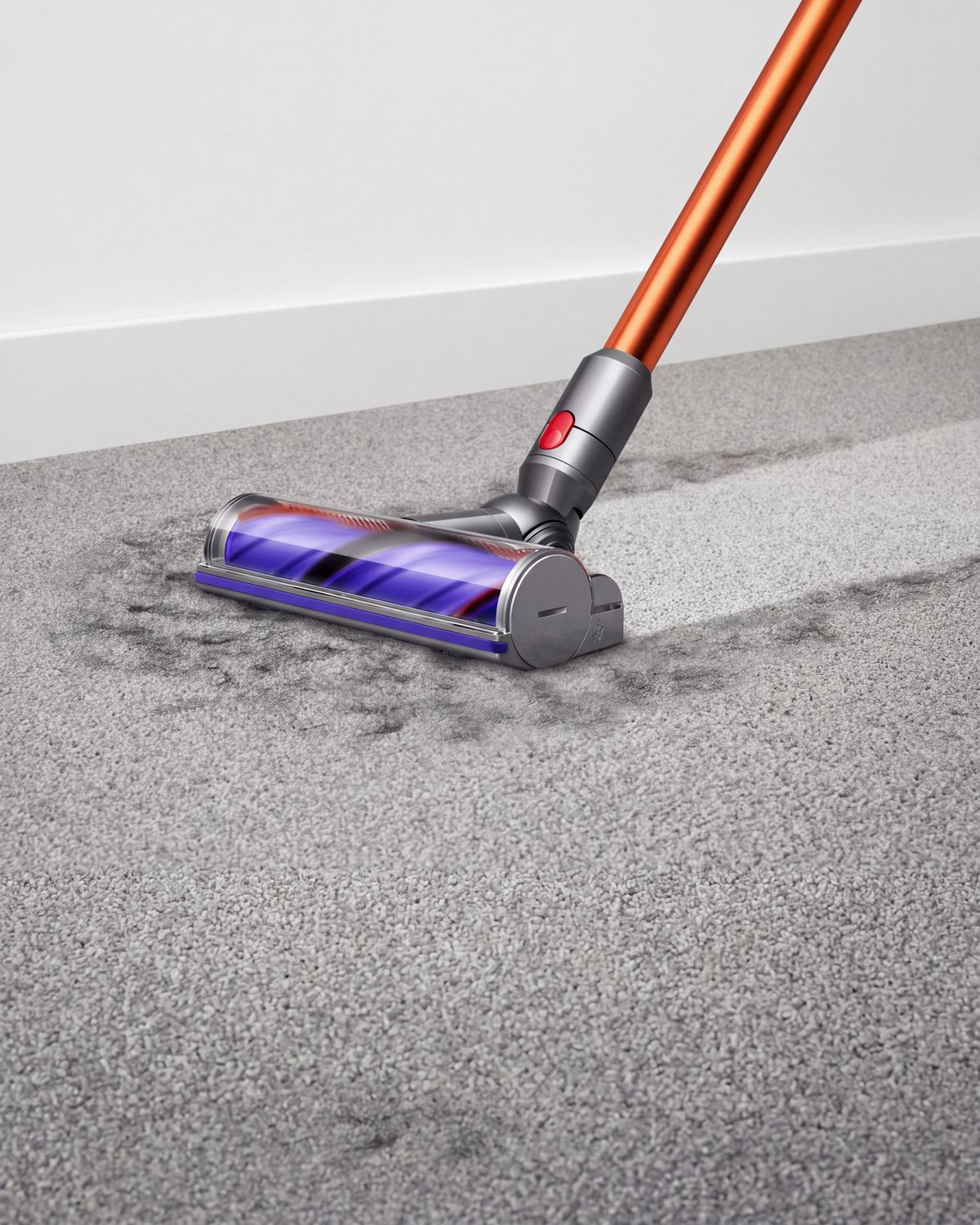 Dyson Motorbar cleaner head used to clean dust and debris from a carpeted floor.