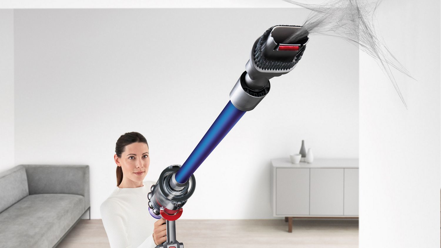 A Dyson V11 cordless vacuum cleaning the corner of a wall with the Combination tool