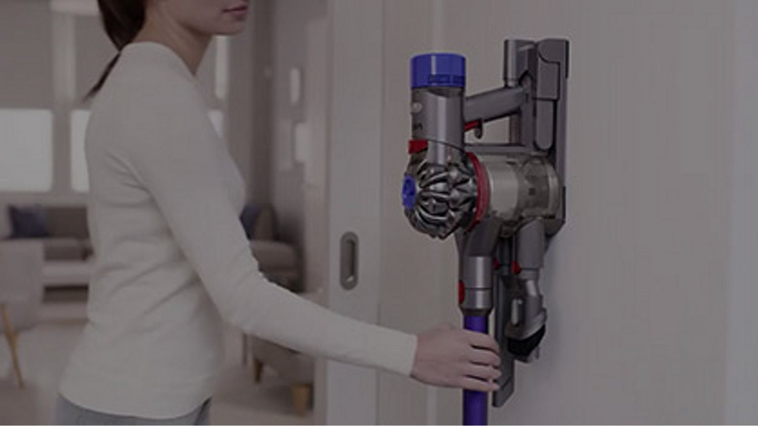 The Dyson V8 vacuum is being returned to its charging dock.