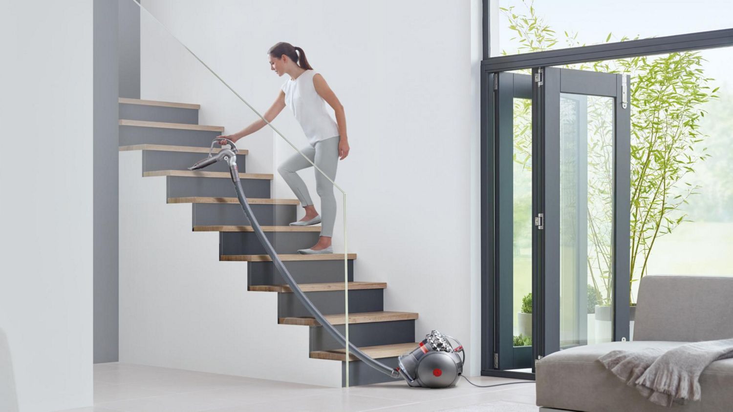 Dyson Big Ball Turbine canister vacuum cleaning stairs with long-reach cord.