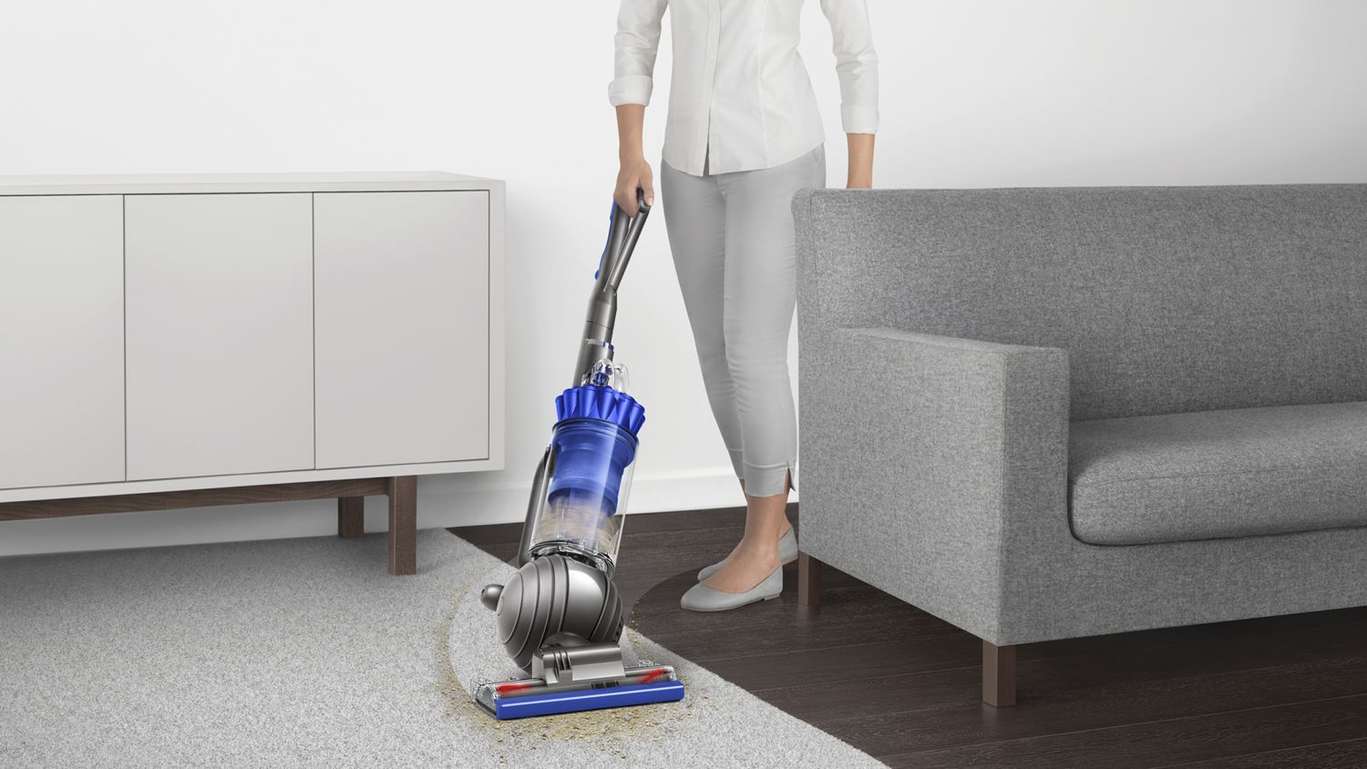 Dyson Ball Total Clean upright vacuum cleaner manoeuvring around furniture to clean floor.