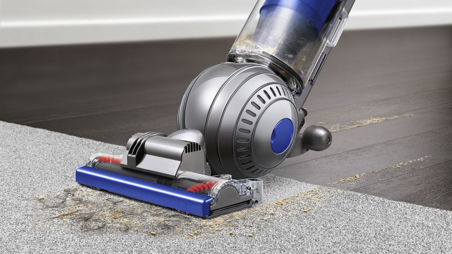 Dyson Ball Total Clean upright vacuum cleaner picking up debris from carpet.