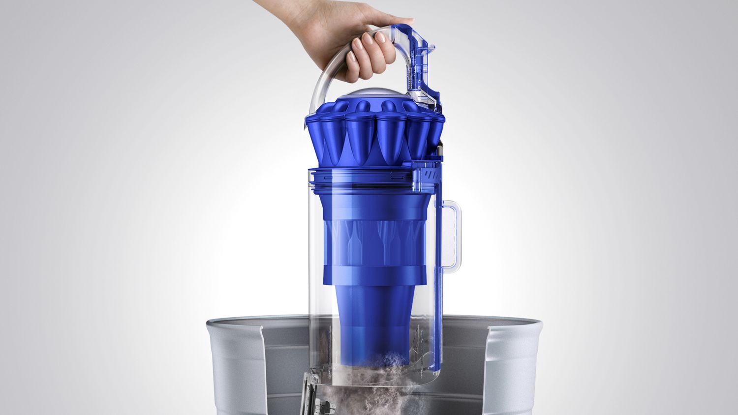 Dyson Ball Total Clean upright vacuum cleaner being emptied in a garbage bin with easy release system. 