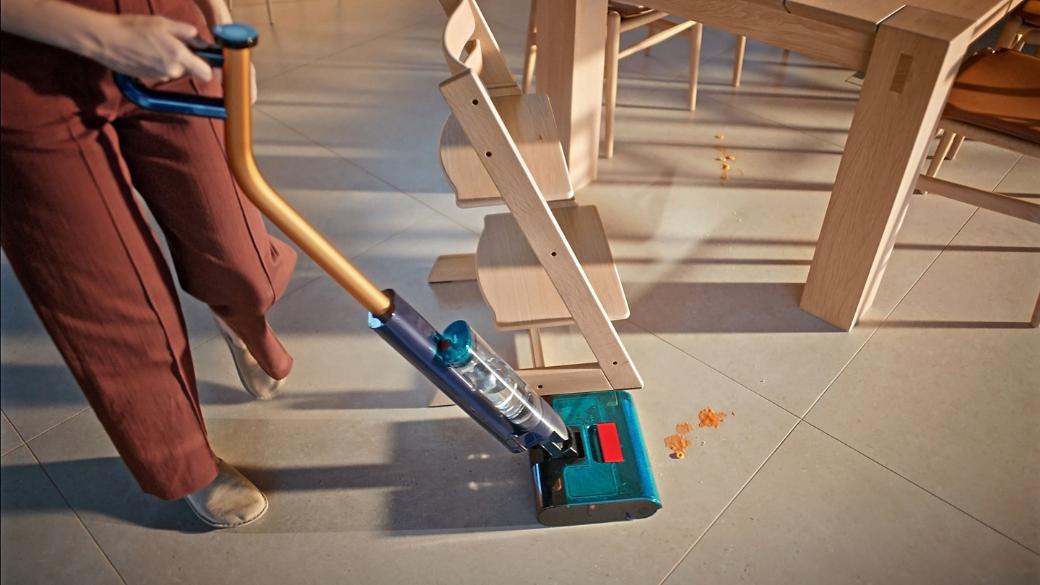 The Dyson Clean+Wash Hygiene hard floor cleaner washing the floor around a table.