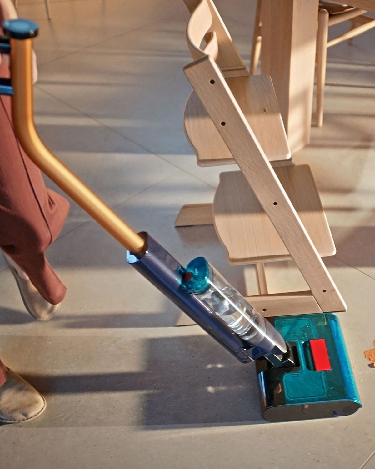 The Dyson Clean+Wash Hygiene hard floor cleaner washing the floor around a table.
