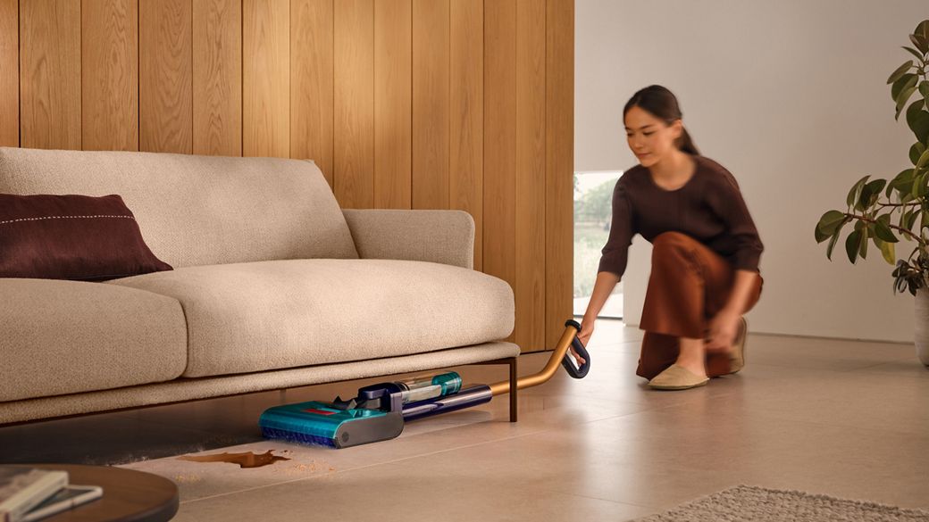 The Dyson Clean+Wash Hygiene hard floor cleaner washing the floor under a sofa.