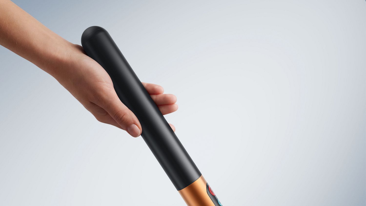 Une main tient la poignée de la batterie du nettoyeur de sols Dyson PencilWash.