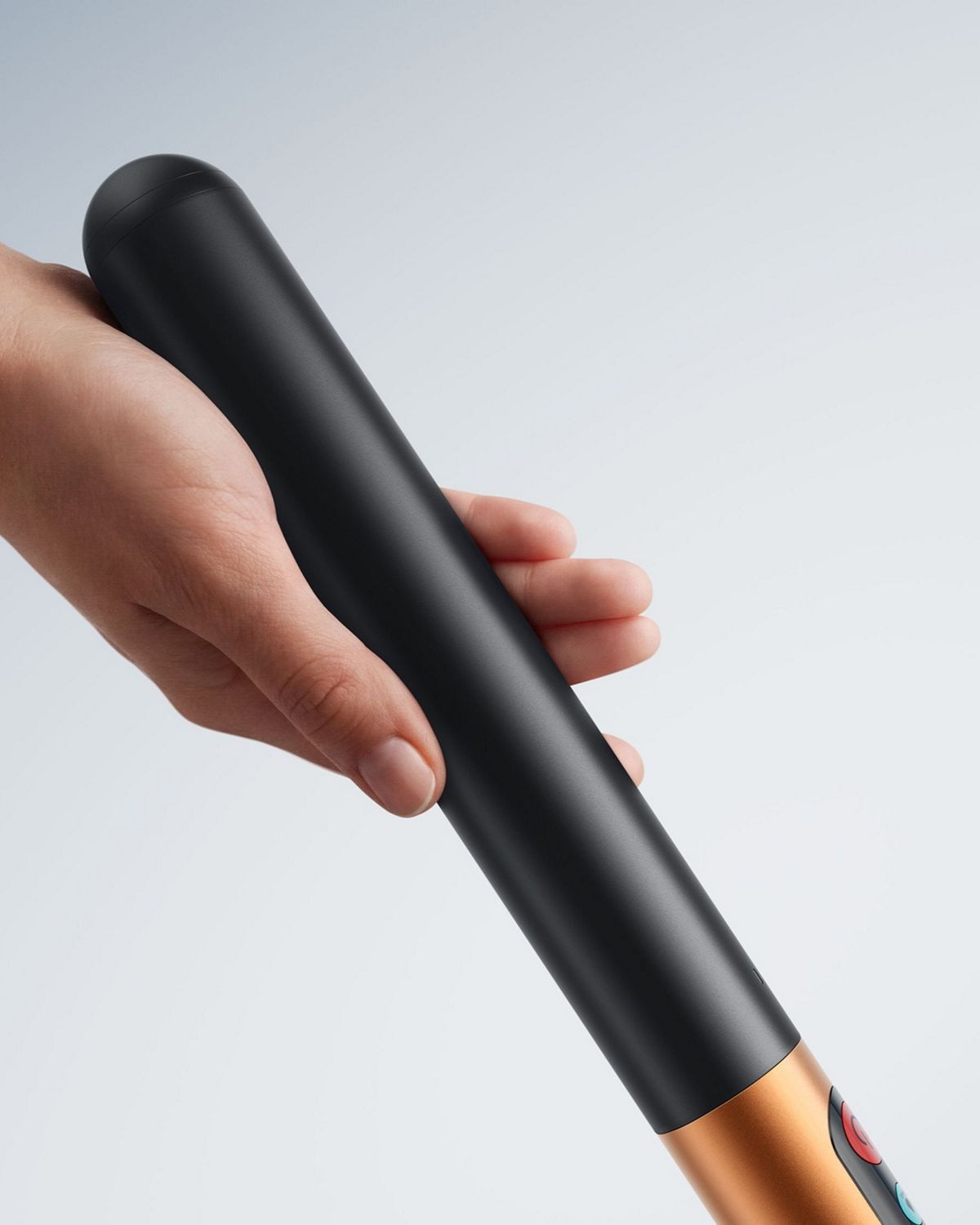 En hand håller i batterihandtaget på Dyson PencilWash-våtdammsugaren.