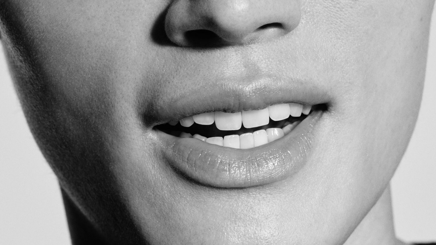 A person smiles to show their healthy white teeth.