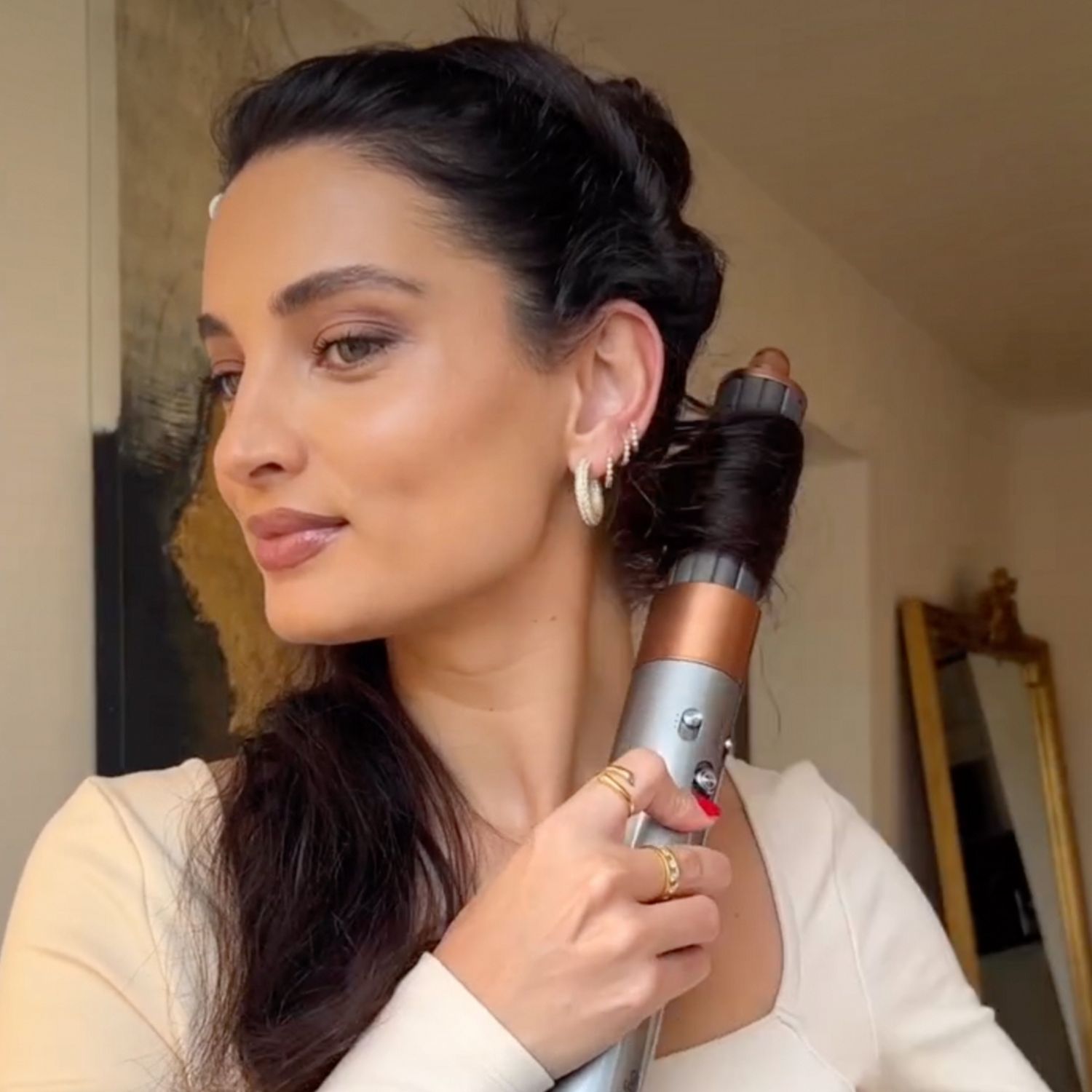 L’asciugacapelli Dyson Supersonic in primo piano, con un cliente sullo sfondo.