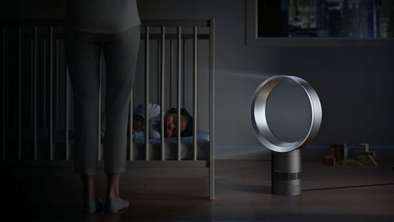 Baby sleeps as Dyson cool desk fan sits in foreground