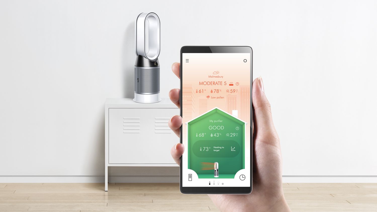 Un purificateur Dyson Hot + Cool est posé sur une table pendant qu’un téléphone intelligent affiche l’application Dyson Link.