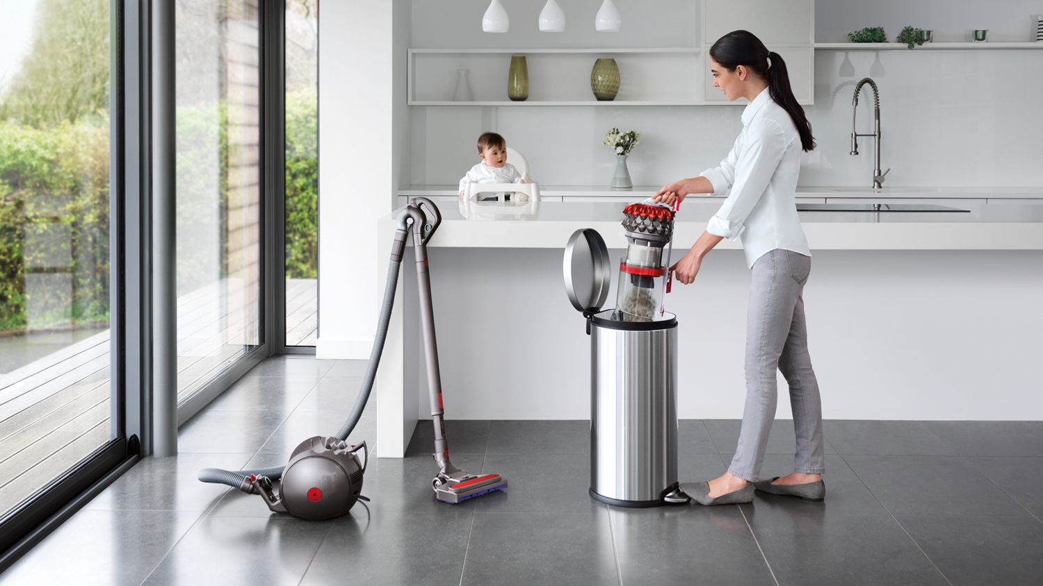 Dyson Big ball canister vacuum cleaner being emptied in a garbage bin with easy release system.