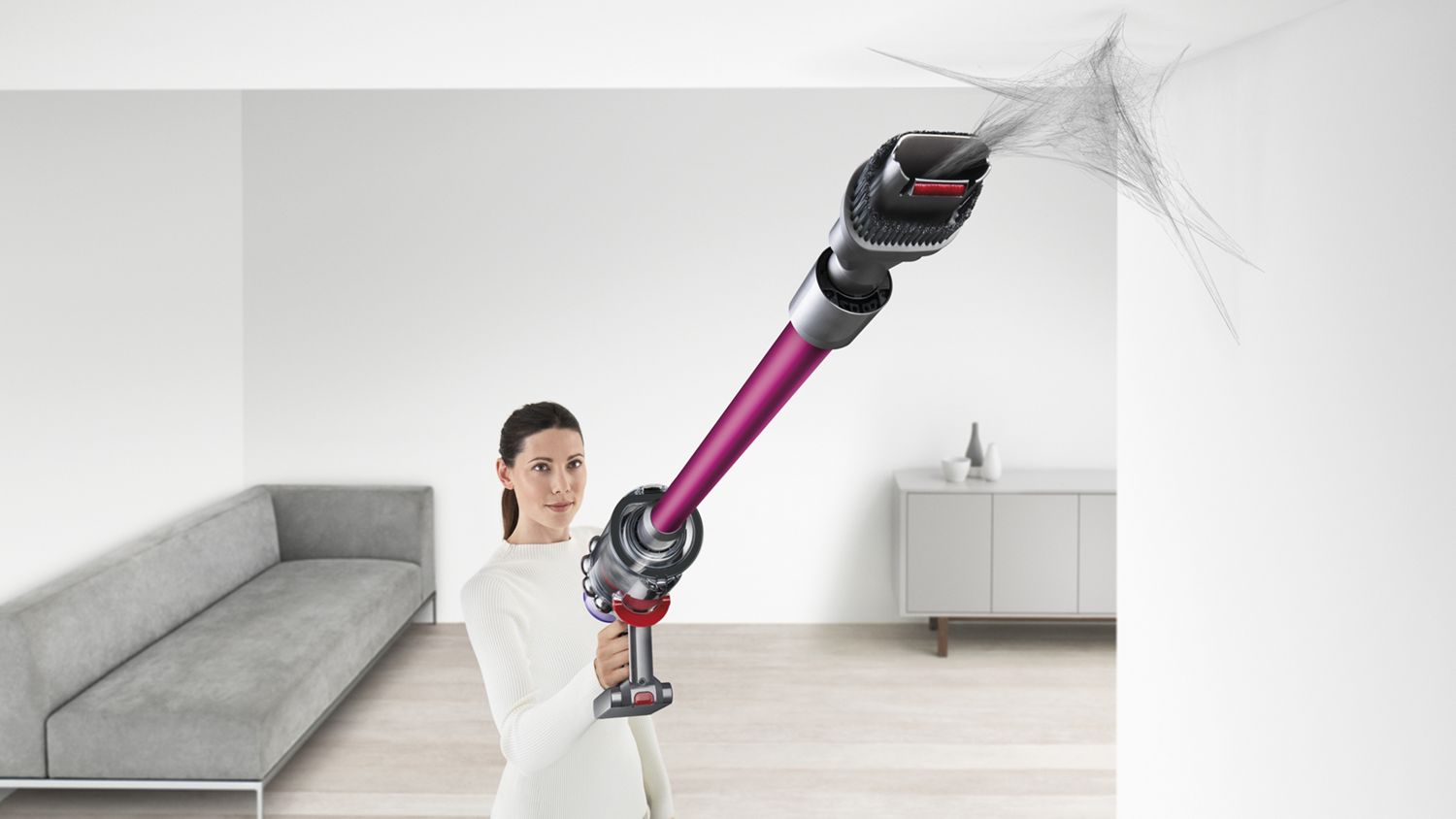 Aspirateur sans fil Dyson V11 Torque Drive avec accessoire éliminant une toile d’araignée dans un recoin.