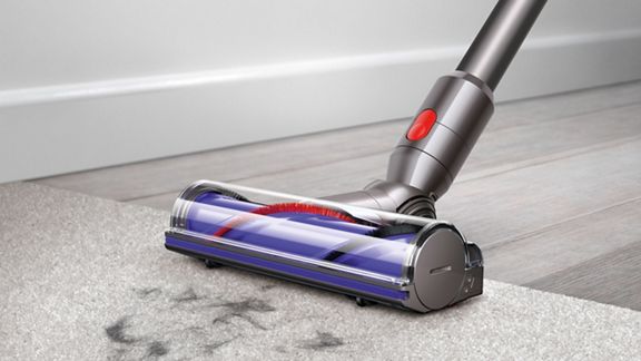Dyson V7 Motorhead cordless vacuum cleaner picking up debris from carpet.
