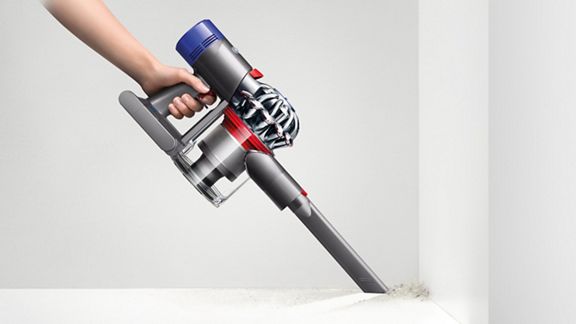 Dyson V7 Motorhead cordless vacuum cleaner in handheld mode cleaning hard to reach area.
