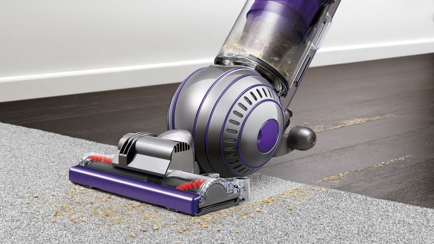 Dyson Ball Animal 2 upright vacuum cleaner picking up debris from carpet.