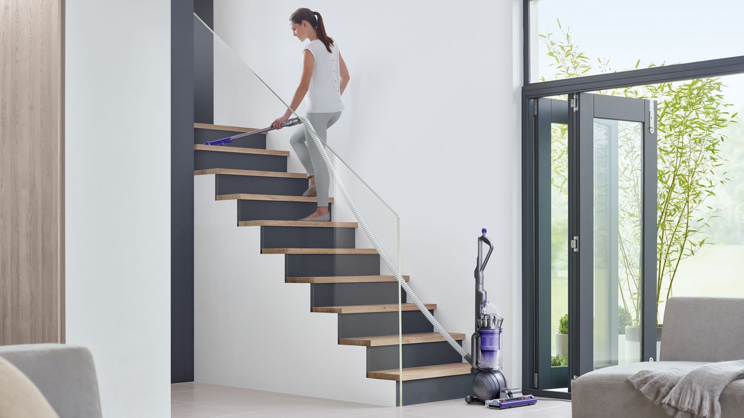 Dyson ball Animal 2 upright vacuum cleaner extendable hose being used to clean the stairs.