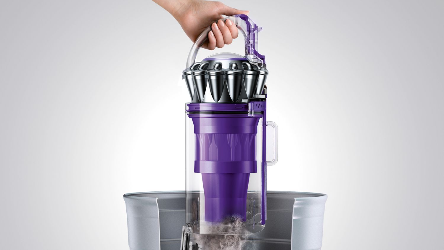 Dyson Animal 2 upright vacuum cleaner being emptied in a garbage bin with easy release system. 