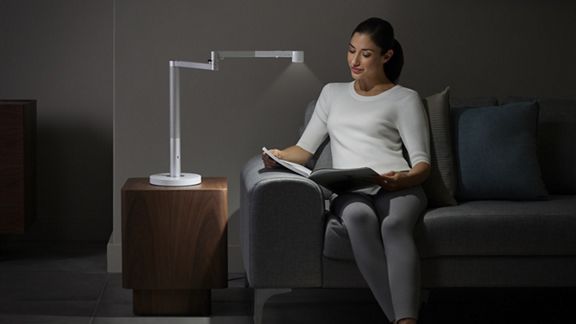 Woman reading under Dyson lightcycle morph.